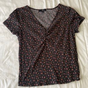 It’s a size medium with a floral design and a v-neck cut with a black background